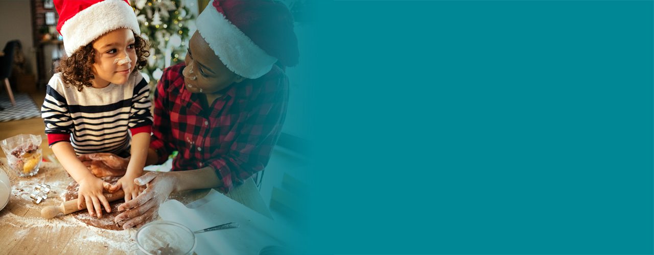 Mother and child wearing Christmas hats and baking